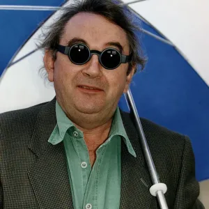 Ian McCaskill wearing a pair of Debenhams Mondo Sunglasses holding umbrella Ian McCaskill wearing a pair of Debenhams Mondo Sunglasses holding umbrella