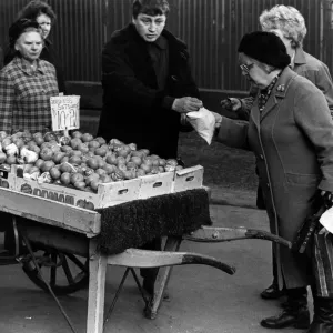 Illegal street trader tommy Quinn makes a sale before having to move on 31st January 1981