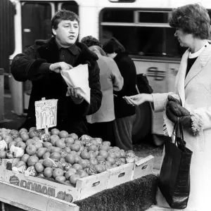 Illegal street trader tommy Quinn makes a sale before having to move on 31st January 1981