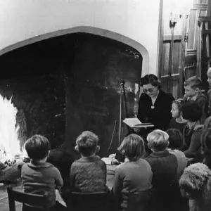 By the inglenook fire of an old English mansion, these happy evacuee children from a By the inglenook fire of an old English mansion, these happy evacuee children from a