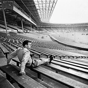 Injured Liverpool footballer Gordon Milne looks out over Wembley Stadium as his teammates
