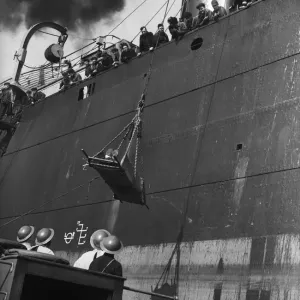 Injury merchant sailor being winched down to a launch during the Second World War Injury merchant sailor being winched down to a launch during the Second World War