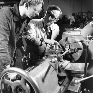 Instructor Bobby Hunter demonstrates lathe turning to apprentice Ian Summerville