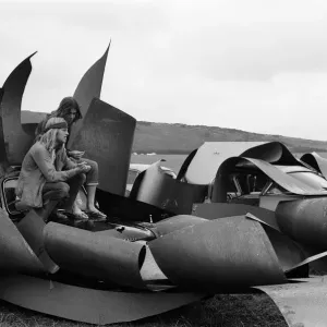 Isle of Wight Festival. Two Swedish hippy types sitting on top of cars that look like Isle of Wight Festival. Two Swedish hippy types sitting on top of cars that look like