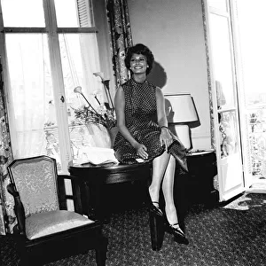 Italian actress Sophia Loren sitting on her desk in her hotel room during the Cannes film