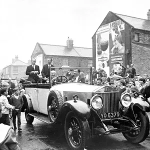 Jack and Bobby Charlton look over-awed as youngsters crowd around the car taking them to Jack and Bobby Charlton look over-awed as youngsters crowd around the car taking them to