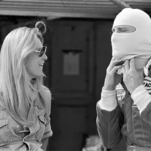 James Hunt talks to a female friend at a practice day for the British Grand Prix held