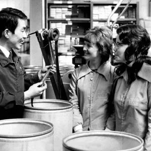 Japanese technician Tadashi Saeki talks with the three machine operators at a Japanese