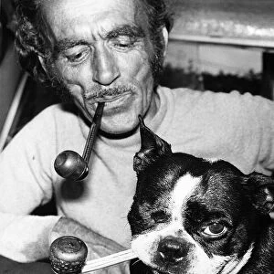 Jean Morel and his dog Butch a Boston Bull Terrier smoke their pipes at home in Devon