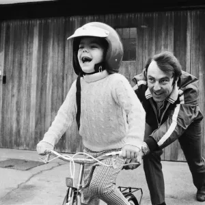 Jimmy Greaves pushing his 4-year old son Andrew, wearing his fathers crash helmet