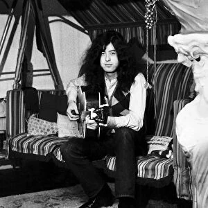 Jimmy Page of Led Zeppelin at home with his guitar