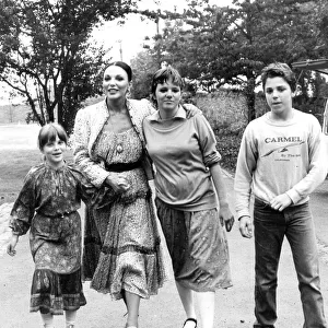 Joan Collins with children Katyana Kass, Tara Newley and Sacha Newley walking in park