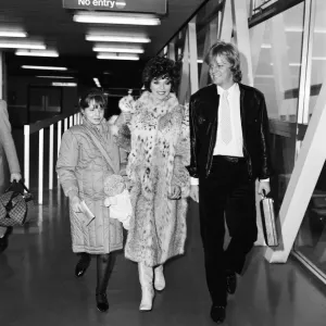 Joan Collins with Family at Heathrow, 22nd December 1983 Print (01086)