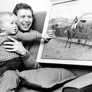 Jockey Brian Fletcher pictured showing his son Andrew a painting of Red Rum landing over
