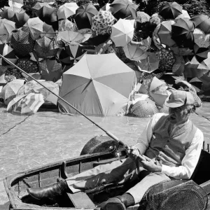 Joe Carver, owner of an umbrella making business, sits in a fishing boat smoking a cigar Joe Carver, owner of an umbrella making business, sits in a fishing boat smoking a cigar