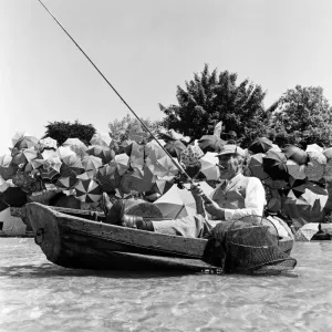 Joe Carver, owner of an umbrella making business, sits in a fishing boat smoking a cigar Joe Carver, owner of an umbrella making business, sits in a fishing boat smoking a cigar