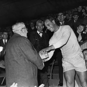 John Charles, le directeur-joueur de Hereford United reçoit le trophée des finalistes de la Coupe du pays de Galles.