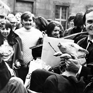 John Cleese at St Andrews ready for a drive around with a piglet