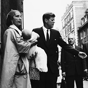 John F Kennedy after the christening of Anna Christina Radziwill who is held by godmother