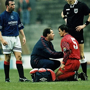 John Inglis of Aberdeen kneeling on ground being treated by a physio after a headbutt by