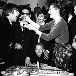 John Lennon being fed birthday cake by Claudette Orbison while her husband Roy