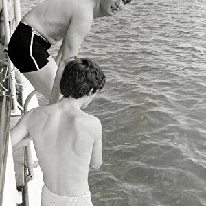 John Lennon and George Harrison of the Pop group The Beatles go for a swim during their