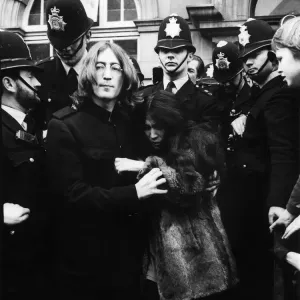 John Lennon with Yoko Ono surrounded by policemen as they leave Marylebone Magistates John Lennon with Yoko Ono surrounded by policemen as they leave Marylebone Magistates