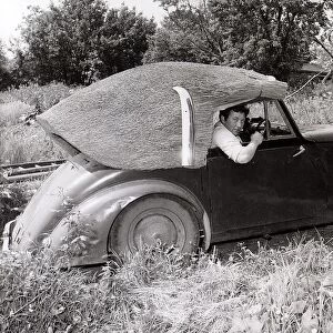 John Porter, a thatcher by trade, has made a thatched roof for his 1949 Allard which he