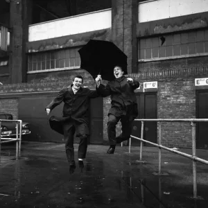 Johnny Byrne and Bobby Moore December 1963 of West Ham United pictured jumping a puddle Johnny Byrne and Bobby Moore December 1963 of West Ham United pictured jumping a puddle