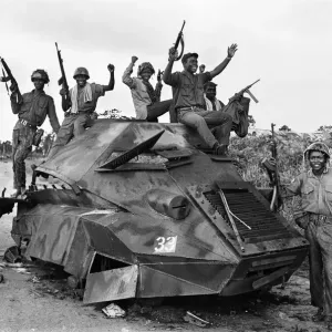 Joyous Biafran soldiers seen here cheering with guns in the air as they sit atop a Joyous Biafran soldiers seen here cheering with guns in the air as they sit atop a