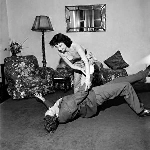 Judo Girl throwing her husband over her shoulder in her living room