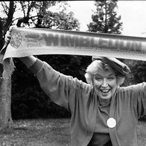June Whitfield, actress and Wimbledon Football Club supporter holds the teams scarf aloft