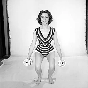Keep-Fit: Woman exercising with dumb bells. 1960