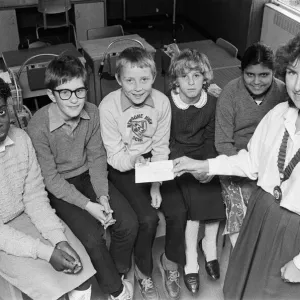 La presidenta de la cámara de comercio junior de Kirklees, la señora Margaret Burnley, presenta un £.