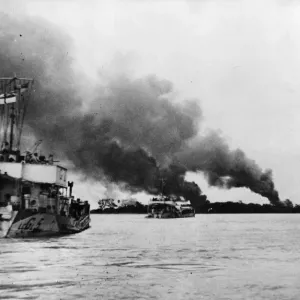 Landing craft travel up the Rangoon (Yangdon) river as smoke from an air strike Landing craft travel up the Rangoon (Yangdon) river as smoke from an air strike