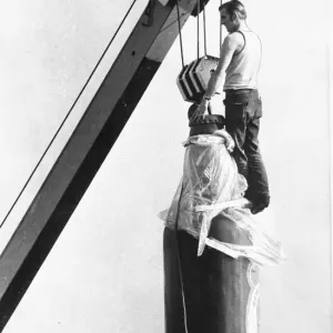 A very large bootle of beer being airlifted