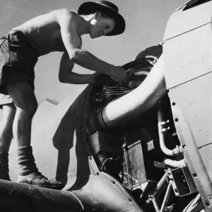 Leading aircraft man R. J. Fennell of Margate, Kent hard at work on the engine of an R. A