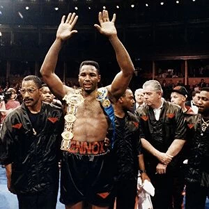 Lennox Lewis Boxer raises his hands with his belts on her shoulders after beating Derek