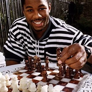 Lennox Lewis Boxing Heavyweight Boxer sitting at table playing chess