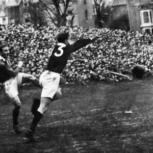 Lewis Jones attempting attempts to clear off the Welsh as his kick is charged down by C. W