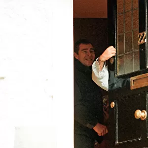 Liam Gallagher puts his hand around the door and gestures to the press
