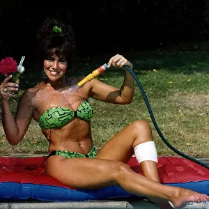 Linda Lusardi Model / TV Presenter sitting by poolside spraying water on to her chest