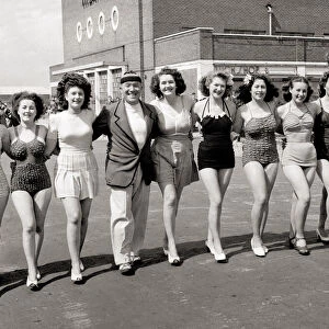 A line-up of girls, women wearing swimming costumes bathing suits bikinis