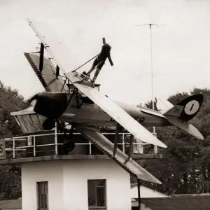 Lisa Winder 24 stands on top of a Tiger Moth Plane as it flys past the watch tower Lisa Winder 24 stands on top of a Tiger Moth Plane as it flys past the watch tower
