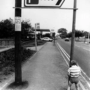 A little boy peeing by a car park sign. Circa 1982