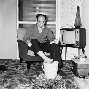 Liverpool and England international footballe Jimmy Melia soothes his injured foot in a Liverpool and England international footballe Jimmy Melia soothes his injured foot in a