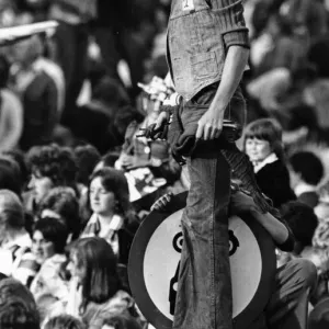 A Liverpool fan gets an elevated view on top of a road sign in William Brown Street as
