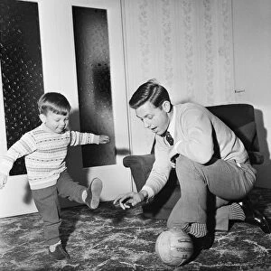 Liverpool football star Gordon Milne gives a coaching lesson to his young son Andrew at