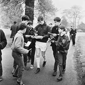 Liverpool footballer Geoff Strong signs autographs for young fans as the team take part