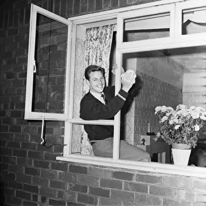 Liverpool footballer Gordon Milne, pictured at his home, cleaning the front windows
